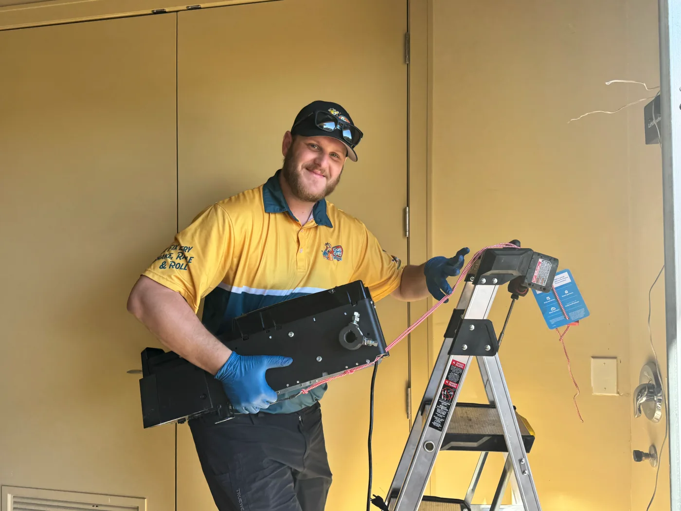 Las Vegas residential garage door technician holding a garage door opener unit