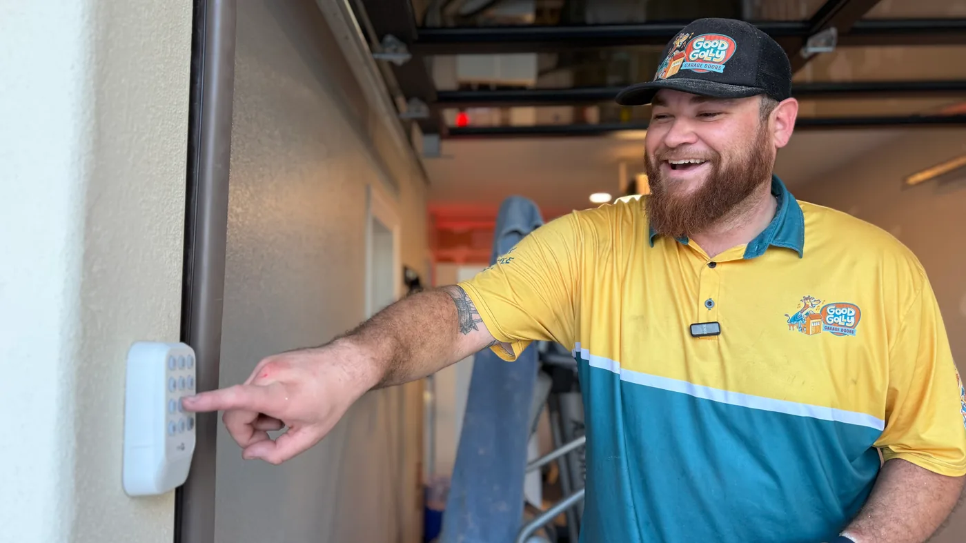 Las Vegas residential garage door technician testing a wall-mounted door control