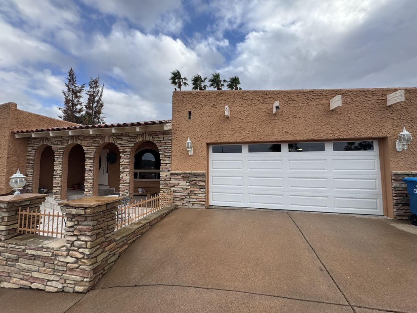 A white long-panel garage door with a window row on a Southwest stone-and-stucco Phoenix home