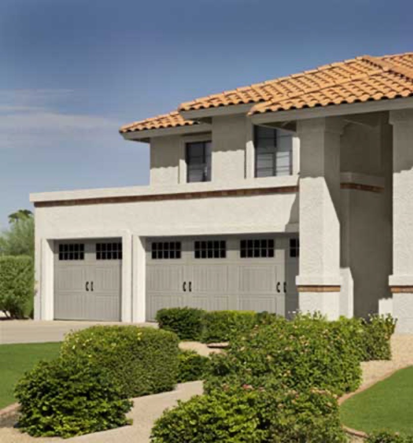 An Amarr Classica carriage-house garage door on a tile-roof stucco home