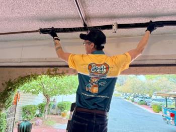 Good Golly Garage Doors employee repairing broken garage door in Henderson