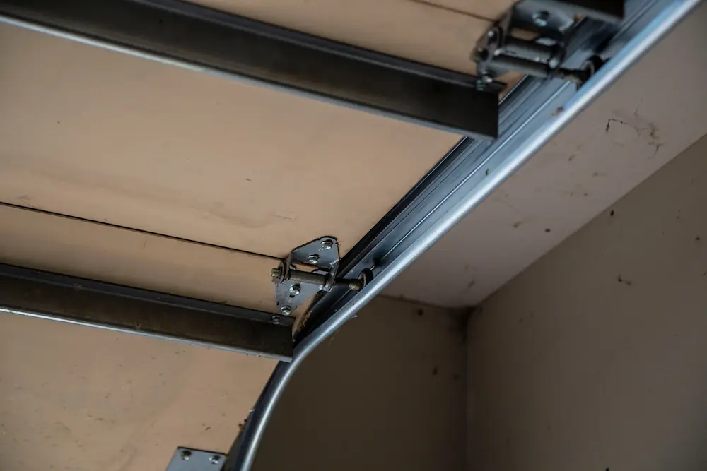 Close-up of garage door track and hinge hardware mounted on ceiling